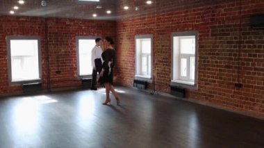 Çekici bir çift dans ediyor. Kadın dansa başlıyor ve erkeği onu izliyor.