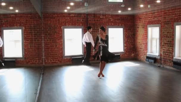 Atrakcyjna para ćwicząca taniec - kobieta rozpoczyna taniec, a jej mężczyzna powoli dołącza do tańca — Wideo stockowe