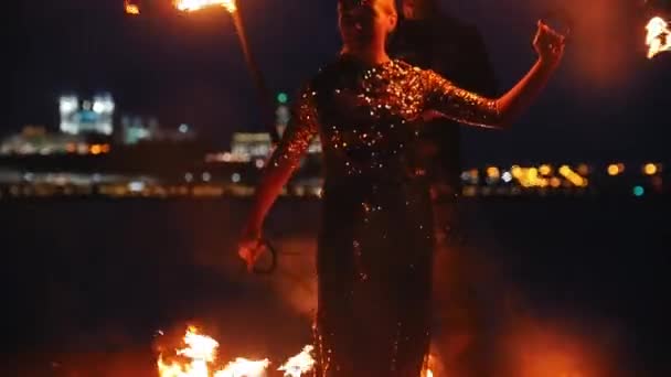 Fire show performance - man och kvinna leker med elden på stranden — Stockvideo