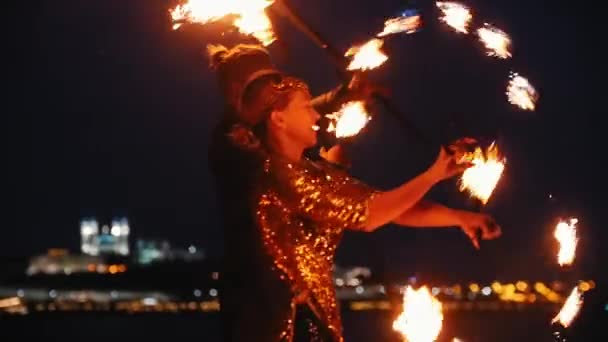 Brand show prestanda - man och kvinna i en glänsande kläder leka med brand facklor på stranden på natten — Stockvideo