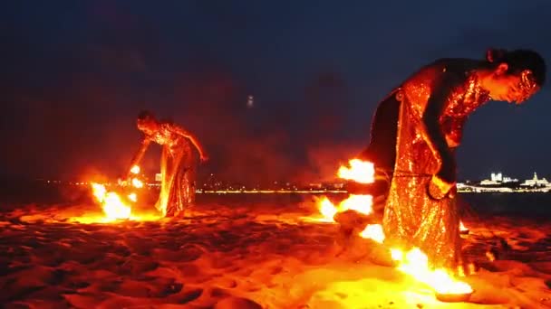Spectacle de feu - deux femmes en robes brillantes allument leurs torches et commencent à danser — Video