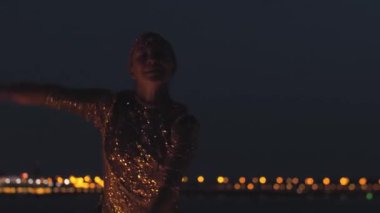 Gülümseyen kadın gece sahilde bir yangın gösterisinde gösteri yapıyor.