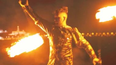 Sakallı adam geceleri zincirlerde yanan iki binayla gösteri yapıyor.