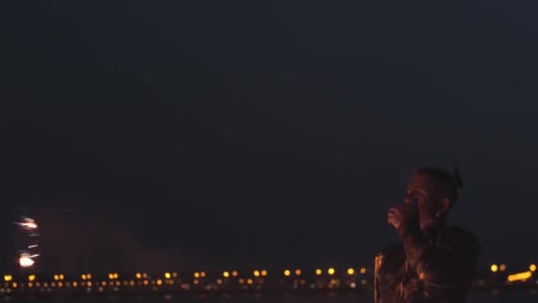 Barbuto uomo performer sputa benzina sul fuoco torcia sulla spiaggia di notte — Video Stock