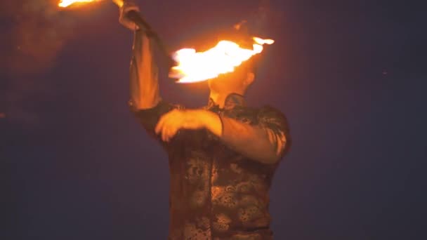 Young man performer dancing and twisting a lit torch in his hands — Stock Video