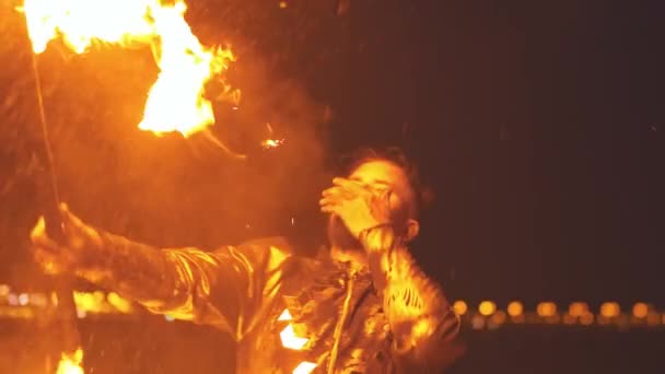 Бородач выступает на огненном шоу - выливает бензин на факел и вытирает губы — стоковое видео