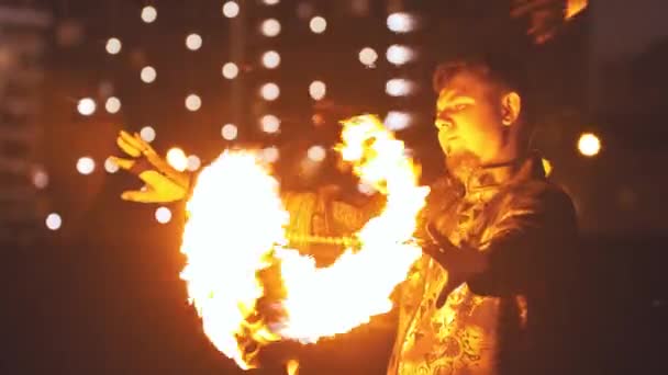 Молодой человек выступает на огненном шоу - играет с горящими фонарями на цепях — стоковое видео