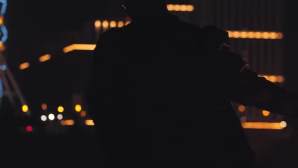Усміхнений чоловік тримає в руці запалену димову бомбу вночі — стокове відео