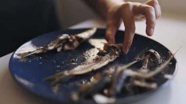 Yemeden önce, dişi ellerinin kemiklerini dikkatlice mavi bir tabakta kızartıyorlar.