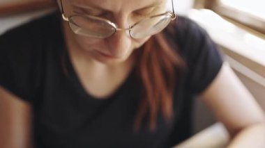 Gözlüklü kadın cam kasede hafif ve sağlıklı sebze salatası yiyor.