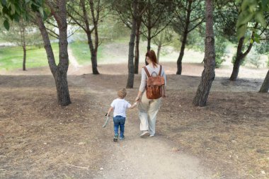 Anne ve oğul ormanda yürürken birlikte güzel vakit geçiriyorlar.