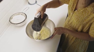 Pasta yapmak için çelik bir kasede yumurta çırpıcı ve elektrikli mikser.