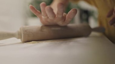 Kadın fırıncılar mutfak tezgahına taze makarna hamuru seriyorlar.