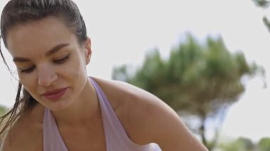 Young athletic woman breathing deeply and resting after an intense workout session in the park