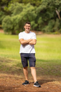 Happy man posing confidently outside in a casual white t-shirt