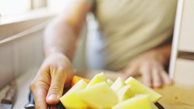 Chef grating potatoes and carrots with a manual grater in a bright kitchen