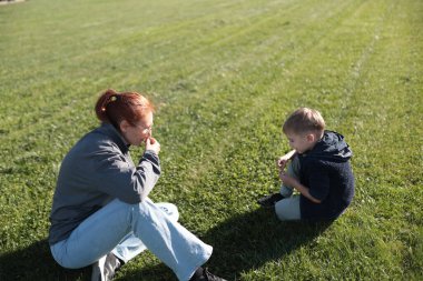 Kadın ve çocuk güneşli bir günün tadını çıkarıyor, doğada birlikte vakit geçiriyorlar.