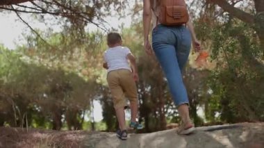 Genç bir kadın ve küçük oğlu bir yaz günü çam ormanında yokuş yukarı yürüyorlar.