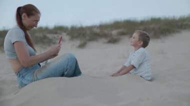 Akıllı telefon fotoğraflarıyla genç bir anne mutlu oğlunu kuma gömdü.