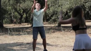 Güneşli bir yaz gününde parkta frizbiyle oynayan mutlu beyaz bir çift.