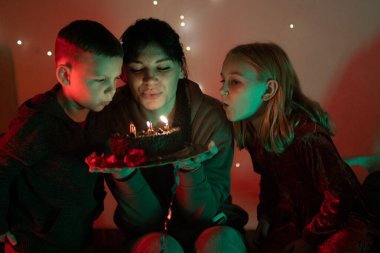 Aile üyeleri doğum günü mumlarını birlikte üflüyorlar. Dilek tutuyorlar.