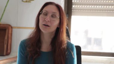 Gözlüklü, zeki, kızıl saçlı iş kadını. Düşüncelerini içeride ifade ediyor.