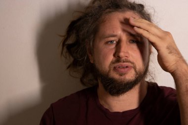 Acı dolu bir ifadeyle zihinsel baskı ve rahatsızlık hisseden bir adam.