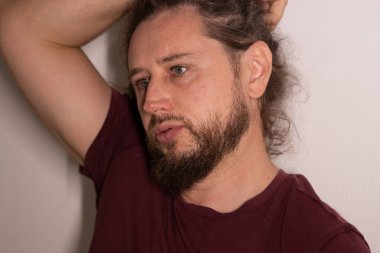 Sakallı adam ciddi düşünüyor, başka tarafa bakıyor, düşüncelerini yansıtıyor.