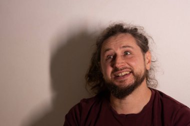 Gülünç bir yüz ifadesi takınan bir adam, gözlerini şaşı bir şekilde dikmiş mizah gösteriyor.