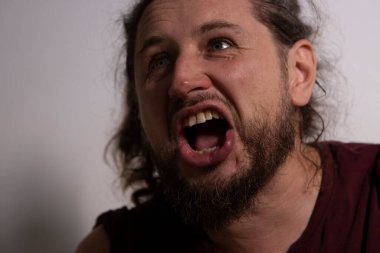Ağzı açık bağıran bir adam yoğun duygular ve sıkıntılar gösteriyor.
