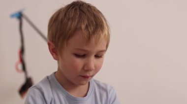 Dijital bir cihazın ekranından aydınlatılan konsantre olmuş genç bir çocuğa yaklaş.