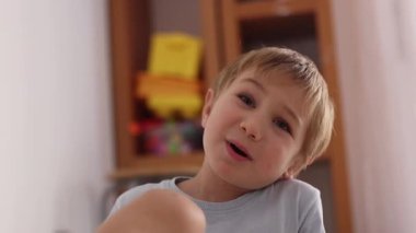 Sevimli küçük çocuk oyun odasına bakarken samimi duygular gösteriyor.