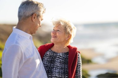 Dışarıda sevgi ve mutlulukla bağ kuran yaşlı çift.