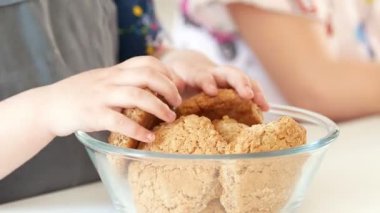 İki küçük kız dökülen meyve çay bardak ev yapımı kurabiye pişirme ile içine yakın çekim