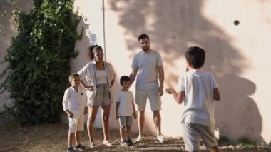 Aile bahçede eğleniyor, duvar topu oynuyor.