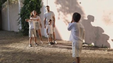 Mutlu bir aile arka bahçelerinde maç seyrediyor.