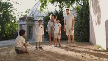 Çocuk parkta oyun oynuyor ve ailesine koşuyor.