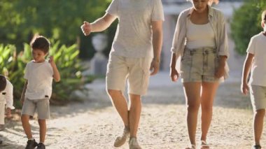 Mutlu çoklu etnik aile parkta birlikte yürümekten zevk alıyor.