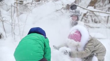 Kış ormanı Parlak elbiseli, karla oynayan neşeli, güler yüzlü çocuklar. Orta çekim
