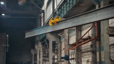 Sanayi konsepti. İnşaat fabrikası. Asılı bir binadan demir ışını çıkaran bir vinç. Orta çekim