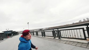 Akrobatik genç performans akrobasi çevirir ve mesire - onun başından kap sinekler - stedycam yavaş hareket, geniş açı takla