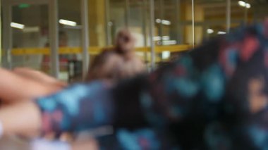 Spor salonundaki kadınlar yoga egzersizleri yapıyor. Telefoto çekimi.