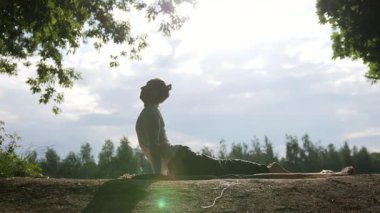 Yoga eğitmeni sportif adam eğitmeni. Sabahın köründe, güneşin önünde yoga yapıyor.