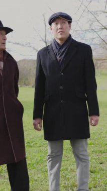 Büyükbaba ve torun parkta sohbet ediyorlar.