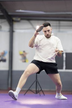 Masa tenisi oynayan sporcu, rekabetçi bir oyun sırasında topa odaklanıyor