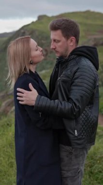 Güzel bir okyanusa bakan bir uçurumda romantik bir anın tadını çıkaran turistler.