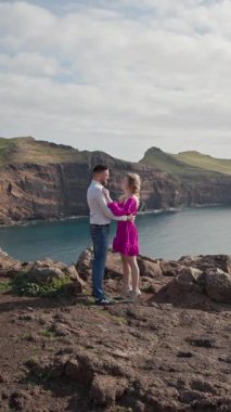 Romantik çift Madeira, Portekiz 'de okyanusa bakan bir uçurumda kucaklaşır.