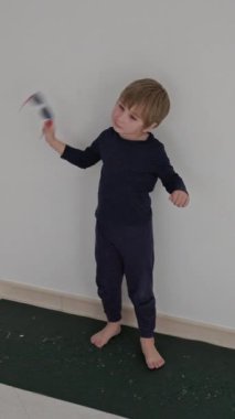 Çocuk minimalist bir ortamda yoga minderinde dans alıştırması yapıyor.