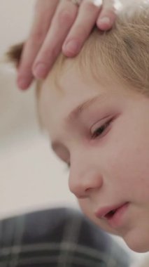 Çocuk saçını evde kestirirken üzülüyor