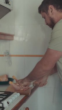 Evcil mutfakta tavuk bacağı kesen adam.